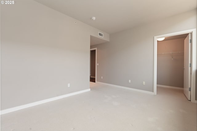 1930 S River Dr Unit W504, Portland, OR 97201 - unfurnished bedroom with a walk in closet, light colored carpet, baseboards, and a closet