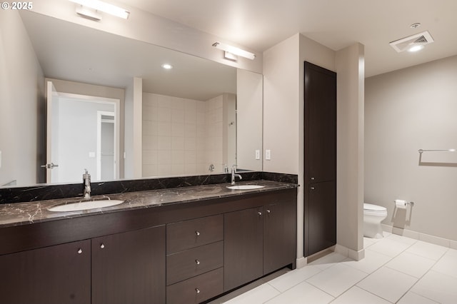 1930 S River Dr Unit W504, Portland, OR 97201 - full bathroom with toilet, double vanity, tile patterned flooring, and baseboards