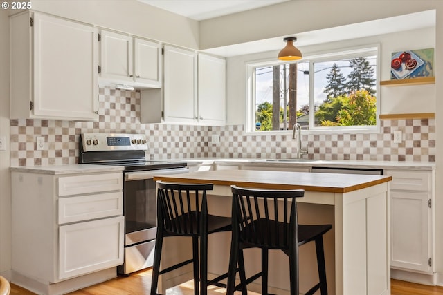 5515 SE 62nd Ave, Portland, OR 97206 - kitchen with stainless steel electric range, a sink, light countertops, and white cabinets