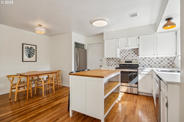5515 SE 62nd Ave, Portland, OR 97206 - kitchen with wood counters, appliances with stainless steel finishes, a sink, open shelves, and tasteful backsplash