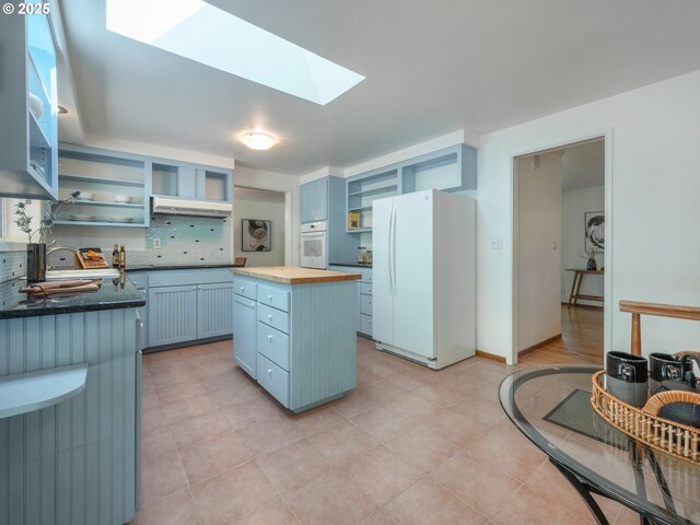 3290 Fillmore St, Eugene, OR 97405 - kitchen with open shelves, white appliances, wooden counters, blue cabinets, and a skylight