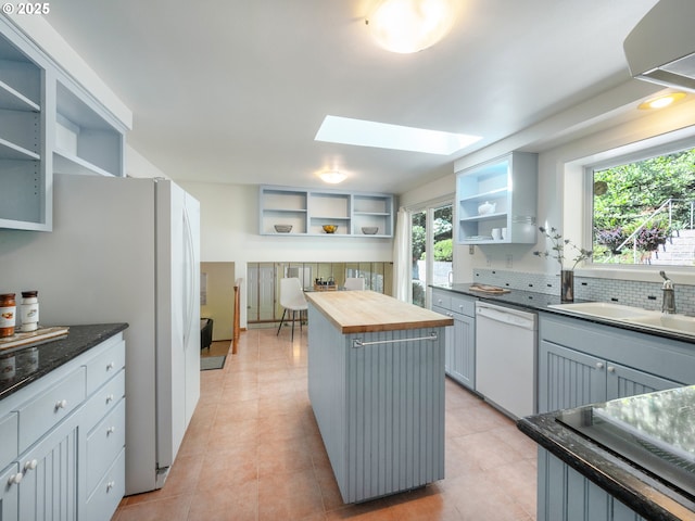 3290 Fillmore St, Eugene, OR 97405 - kitchen with open shelves, white appliances, butcher block counters, a skylight, and a kitchen island