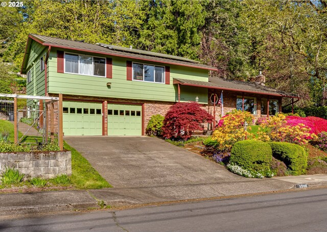3290 Fillmore St, Eugene, OR 97405 - view of front of house with an attached garage, solar panels, driveway, brick siding, and a metal roof