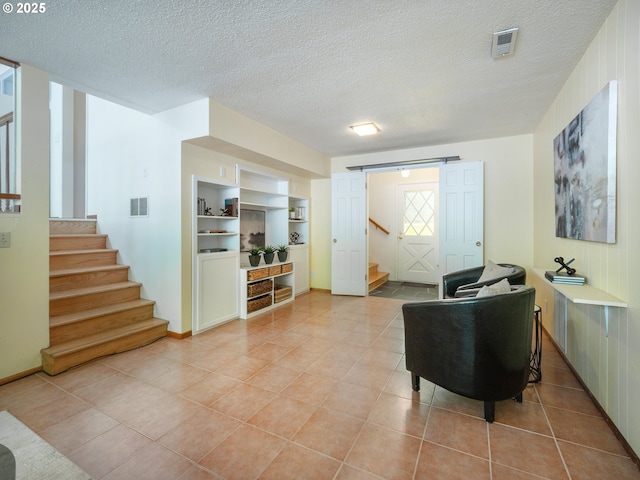 3290 Fillmore St, Eugene, OR 97405 - living area with stairway, light tile patterned floors, a barn door, and a textured ceiling