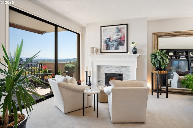 carpeted living area featuring a glass covered fireplace
