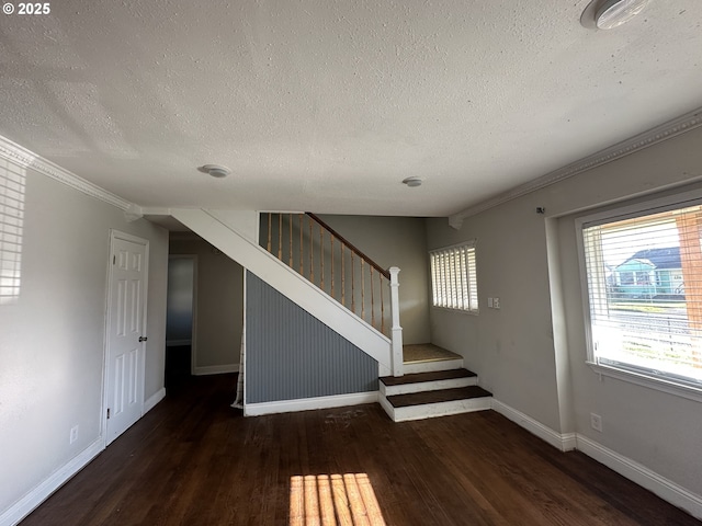 staircase featuring hardwood / wood-style flooring, a textured ceiling, and ornamental molding