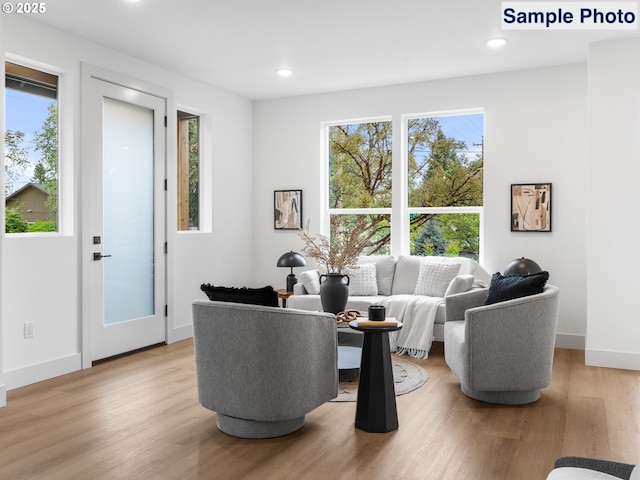 living room featuring recessed lighting, light wood finished floors, and a wealth of natural light
