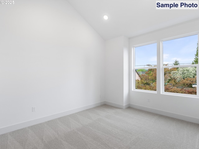 empty room featuring baseboards, recessed lighting, vaulted ceiling, and light carpet