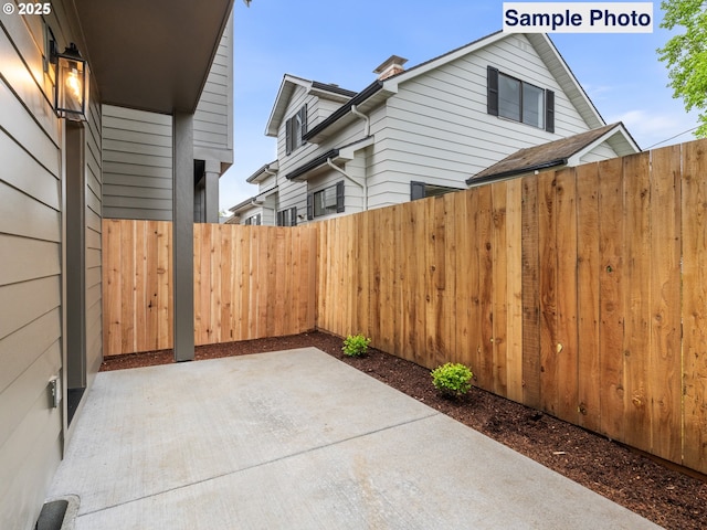 view of side of home featuring fence and a patio area