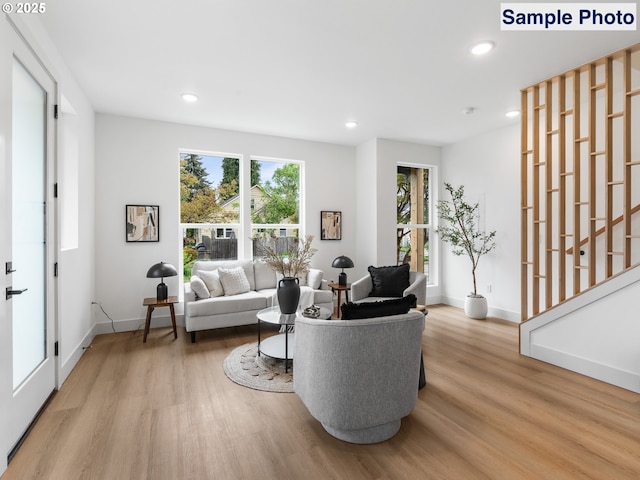 living room with recessed lighting, baseboards, and wood finished floors
