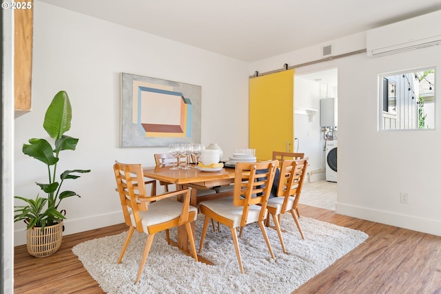 1368 Boca Ratan Dr, Lake Oswego, OR 97034 - dining space with a wall mounted air conditioner, light wood finished floors, stacked washer and clothes dryer, and a barn door