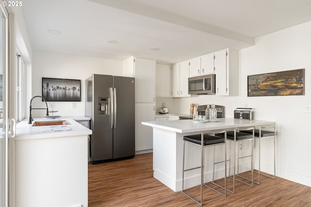 1368 Boca Ratan Dr, Lake Oswego, OR 97034 - kitchen featuring stainless steel appliances, a peninsula, wood finished floors, and white cabinetry