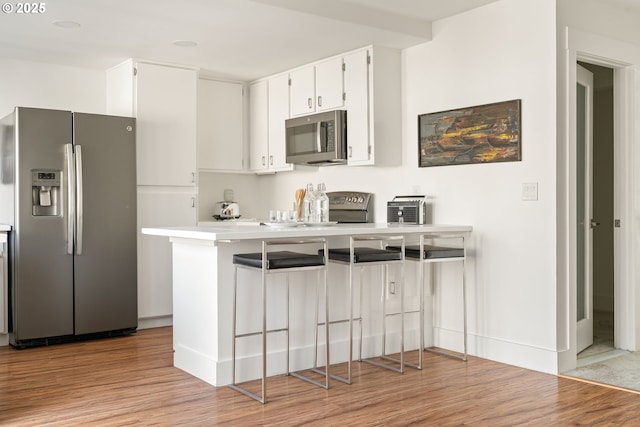 1368 Boca Ratan Dr, Lake Oswego, OR 97034 - kitchen with appliances with stainless steel finishes, light wood-type flooring, and white cabinets