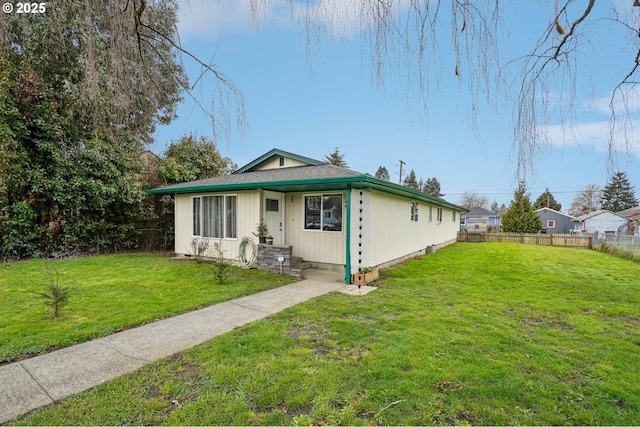 bungalow-style home with a front yard and fence