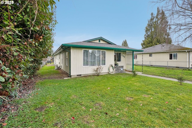 view of front of home featuring a front yard, fence, roof with shingles, and crawl space