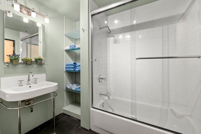 bathroom with combined bath / shower with glass door, sink, and tile patterned floors