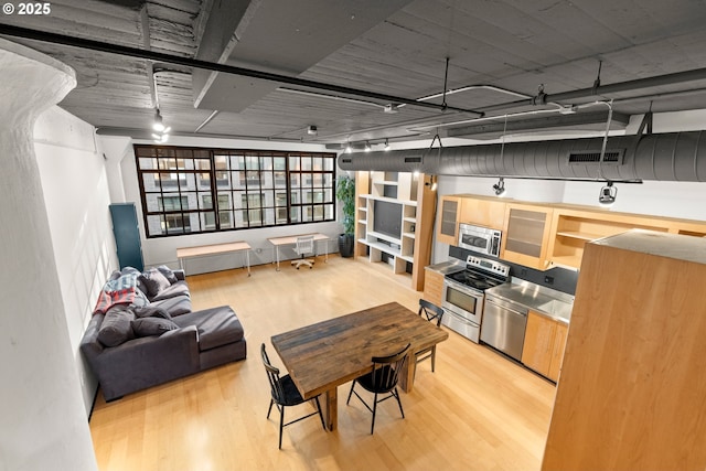 interior space with appliances with stainless steel finishes and light wood-type flooring