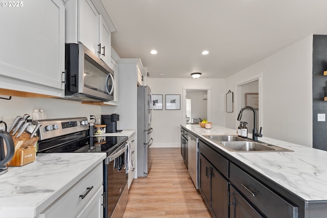 1410 NW Keasey St, Roseburg, OR 97471 - kitchen featuring stainless steel appliances, a sink, light wood finished floors, white cabinets, and recessed lighting