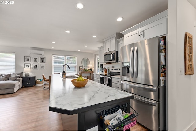 1410 NW Keasey St, Roseburg, OR 97471 - kitchen with appliances with stainless steel finishes, a sink, a wall mounted air conditioner, recessed lighting, and a kitchen island with sink