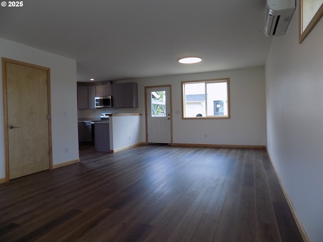 545 SE Firefly Ave, Corvallis, OR 97333 - unfurnished living room featuring a wall mounted air conditioner, baseboards, dark wood finished floors, and recessed lighting