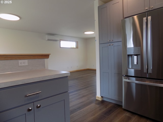 545 SE Firefly Ave, Corvallis, OR 97333 - kitchen with stainless steel fridge with ice dispenser, a wall mounted air conditioner, dark wood-type flooring, gray cabinets, and baseboards