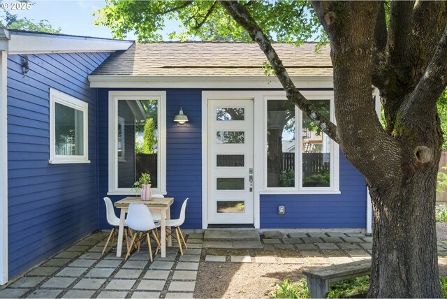7228 N Villard Ave, Portland, OR 97217 - property entrance with a patio and roof with shingles