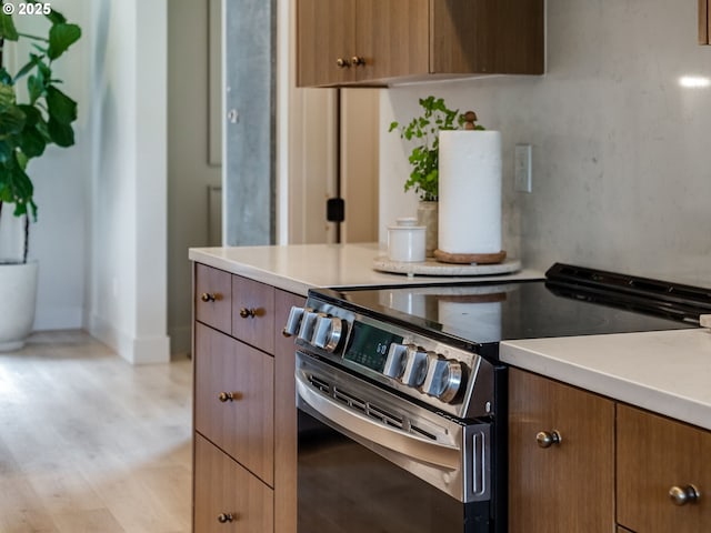 215 Cowlitz Vista Rd, Toledo, WA 98591 - kitchen featuring stainless steel electric range, light countertops, light wood-style flooring, and brown cabinets