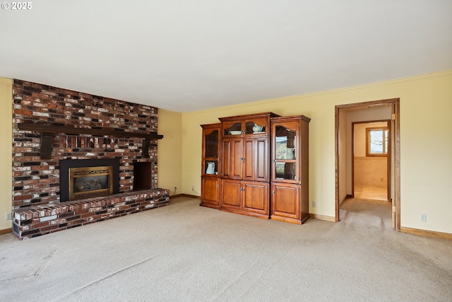 unfurnished living room with baseboards, a brick fireplace, and light colored carpet