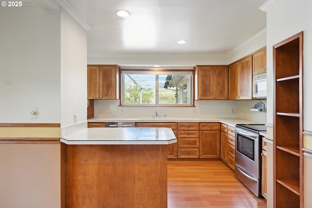 kitchen featuring brown cabinets, a sink, ornamental molding, stainless steel appliances, and light wood-style flooring