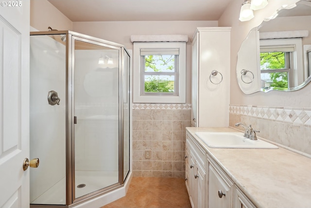 bathroom with plenty of natural light, tile walls, tile patterned flooring, and a shower stall