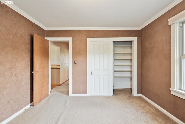 unfurnished bedroom with baseboards, crown molding, carpet floors, and a closet