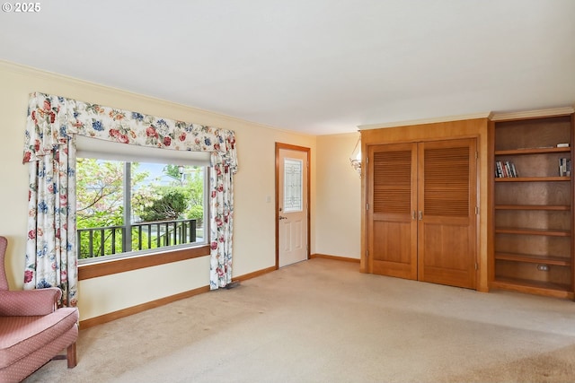 unfurnished room featuring baseboards, ornamental molding, and carpet