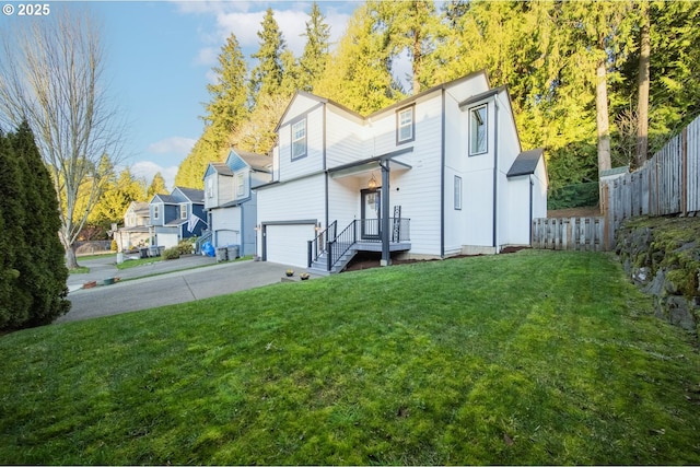 back of house with a garage and a yard