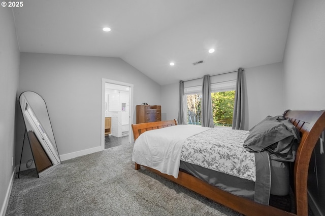 bedroom featuring dark carpet, ensuite bath, and vaulted ceiling