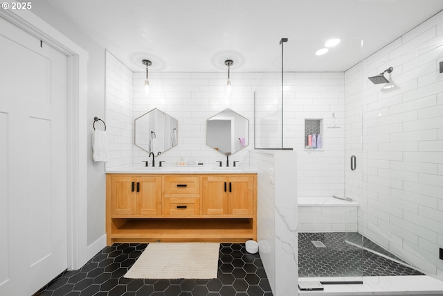 bathroom featuring vanity, tasteful backsplash, tile patterned floors, and walk in shower