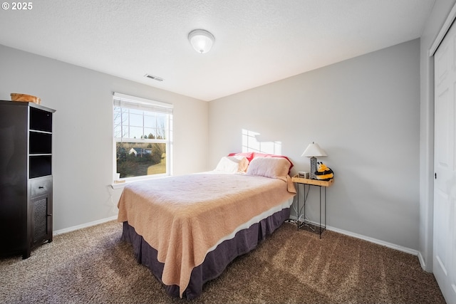 carpeted bedroom with a closet and a textured ceiling