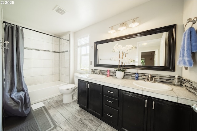 full bathroom featuring tiled shower / bath combo, vanity, backsplash, and toilet