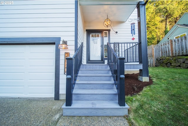 view of exterior entry featuring a yard and a garage