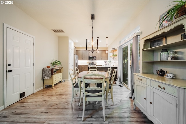 dining area with an inviting chandelier and light hardwood / wood-style floors