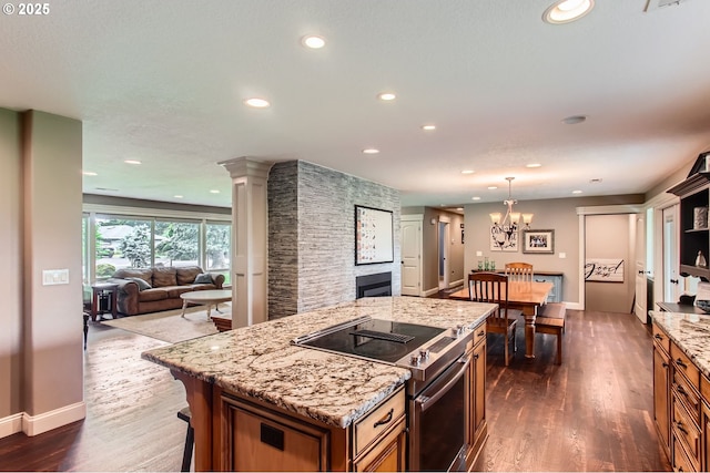 10588 Crosby Rd NE, Woodburn, OR 97071 - kitchen with electric stove, dark wood finished floors, open floor plan, a fireplace, and a center island