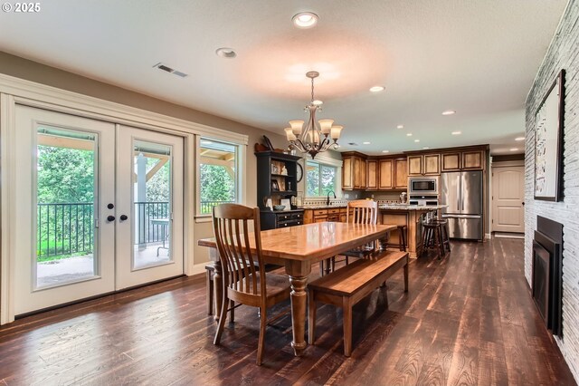 10588 Crosby Rd NE, Woodburn, OR 97071 - dining room featuring a chandelier, dark wood-style floors, recessed lighting, a fireplace, and french doors