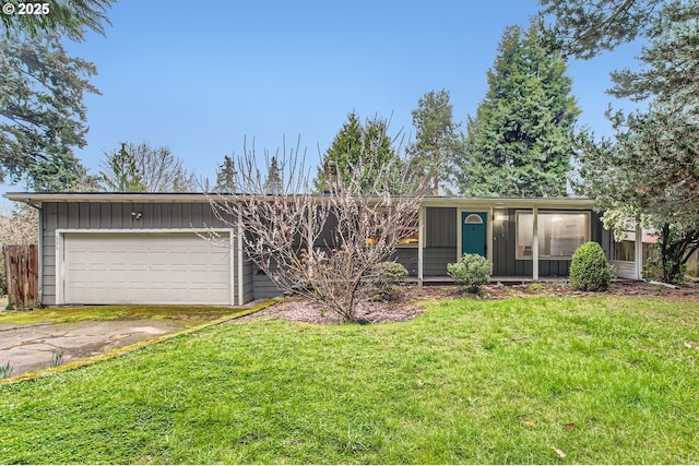 view of front facade with driveway, board and batten siding, and a front yard