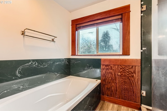 bathroom featuring a bath and wood finished floors