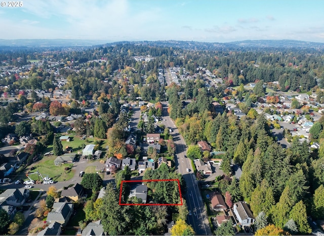 drone / aerial view featuring a residential view and a wooded view