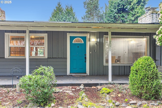 property entrance with board and batten siding and a chimney