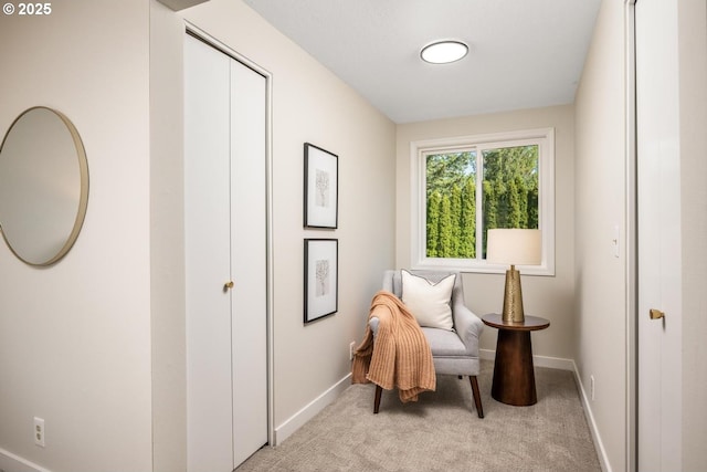 sitting room featuring baseboards and light colored carpet