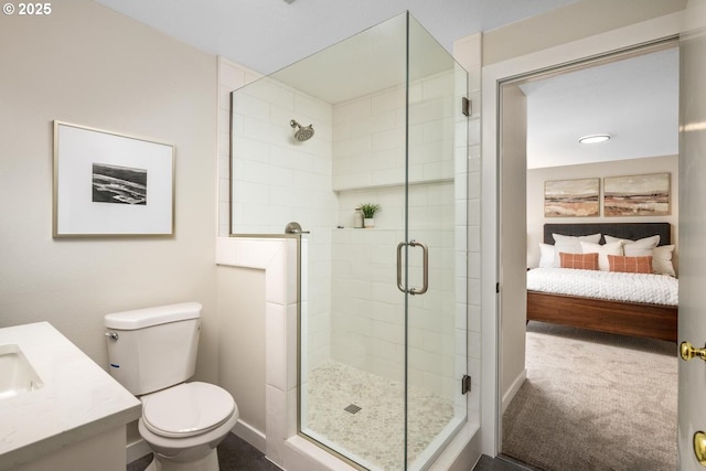 ensuite bathroom with a shower stall, toilet, vanity, and baseboards
