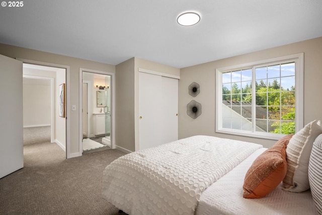 carpeted bedroom featuring baseboards, ensuite bath, and a closet