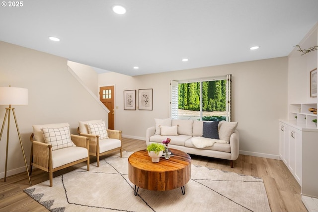 living room with light wood-style flooring, baseboards, recessed lighting, and stairway