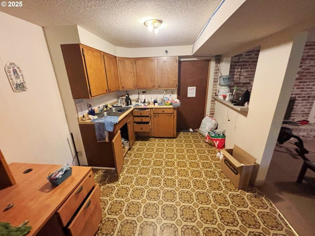 17373 SE Forest Hill Dr, Damascus, OR 97089 - kitchen with a textured ceiling, brown cabinets, light countertops, light floors, and a sink